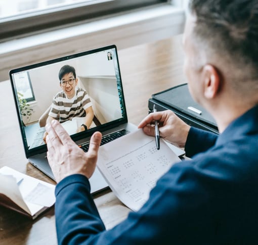 Man looking at a laptop on a video meeting