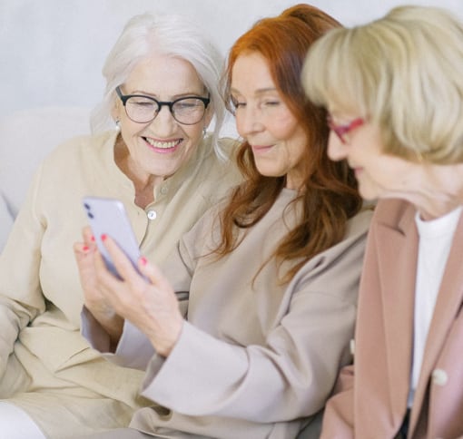 Three women looking at a smart phone video chatting